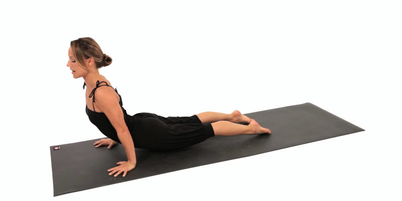 Yoga practitioner demonstrates upward dog, aka up dog, on her yoga mat.