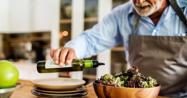 Old guy pours olive oil over his dressing!