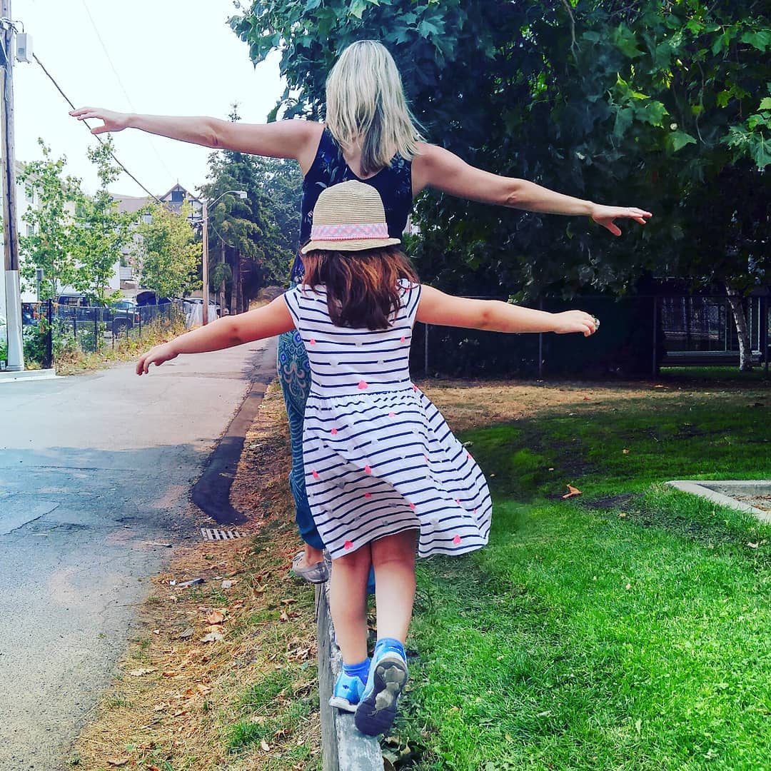 Mom and daughter balance on a beam