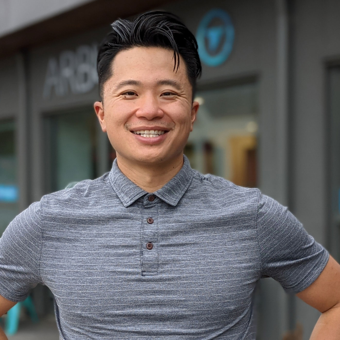 Thomas Zhou stands in front of Arbutus Physiotherapy & Health Centre.