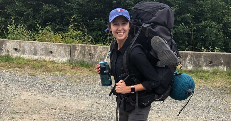 Emily Jackson smiles while wearing her backcountry hiking backpack.