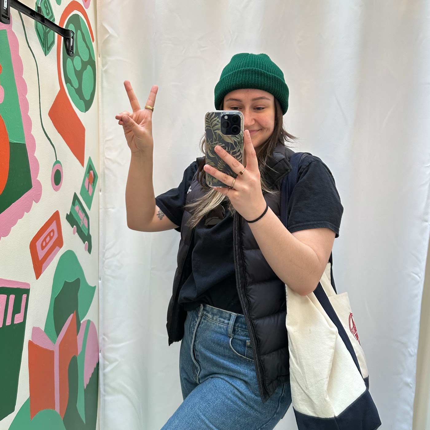 Mackenzie Wensauer flashes a peace sign in a thrift store change room.