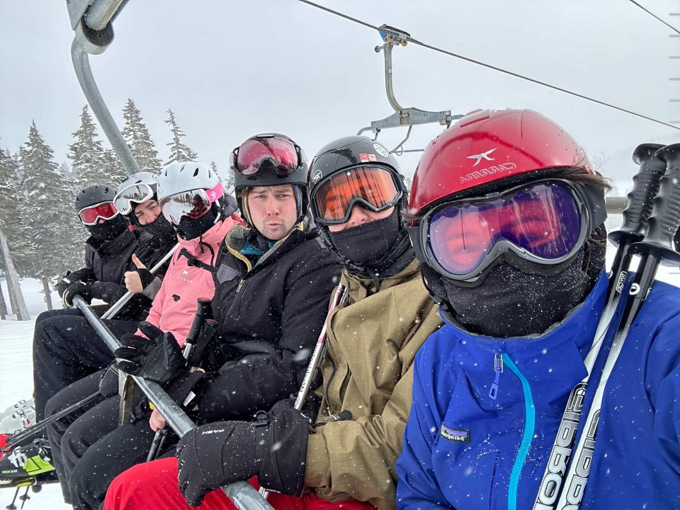 Mackenzie Wensauer sits on a ski lift with her friends, in the snow and pow pow.