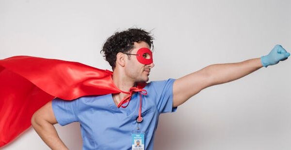 Brave doctor in flying superhero cape with fist stretched.