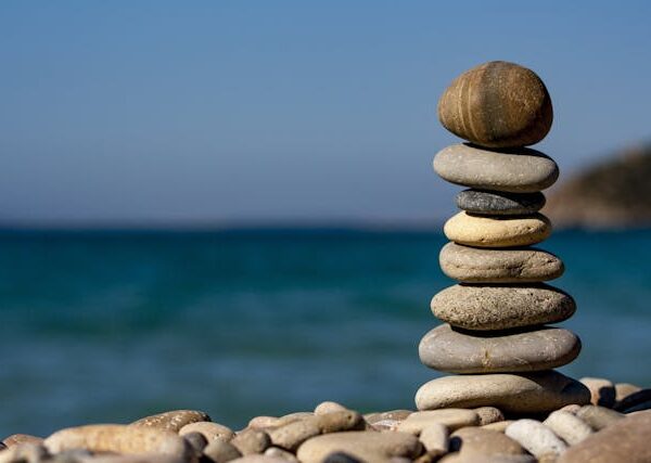 A stack of flat pebbles balances in front of a blue-green ocean.