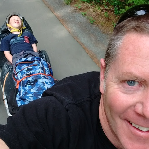 David Lacey bikes with his child.