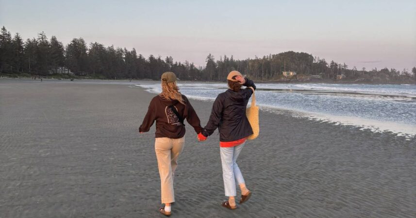 Hailey Frampton holds hands with a girl friend while they walk along a beach in Tofino, British Columbia.