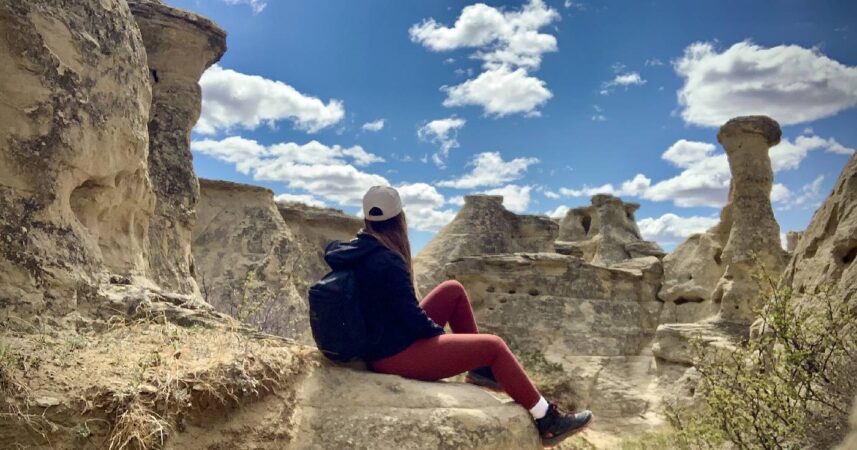 Kennedy Tralnberg sits on top of a hoodoo in Alberta.