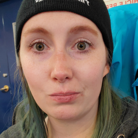 Casey McDowall stares, non smiling, and kind of silly, with wide open eyes, wearing a toque.